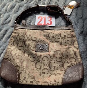 Lot 213 This item is a brown patterned GUESS mini crossbody bag. 